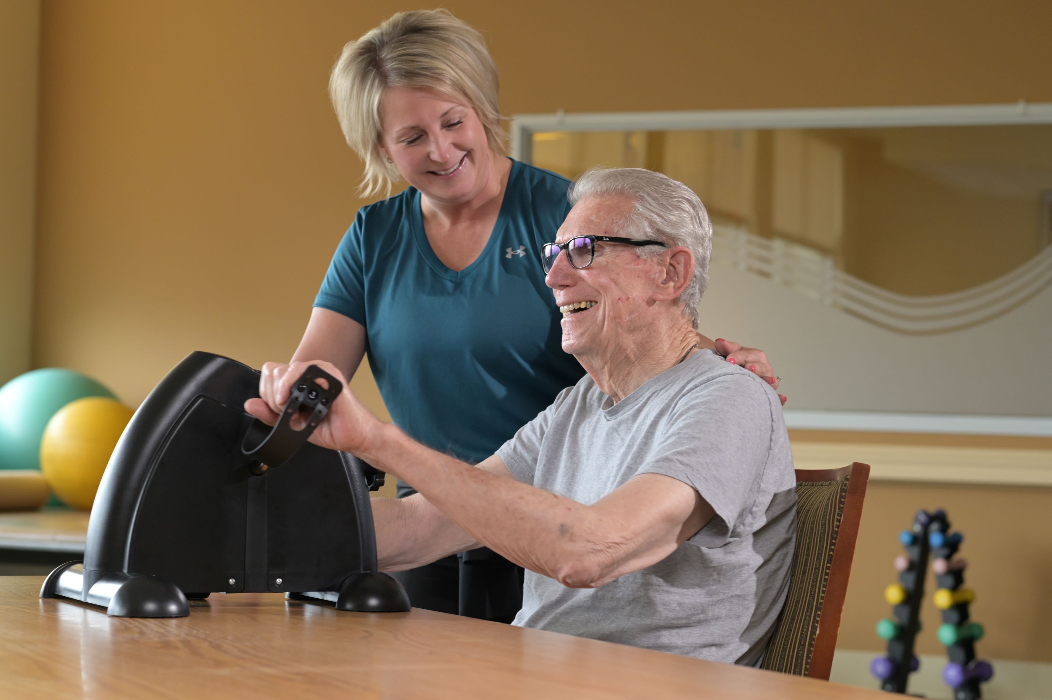 therapist with resident using hand cycle